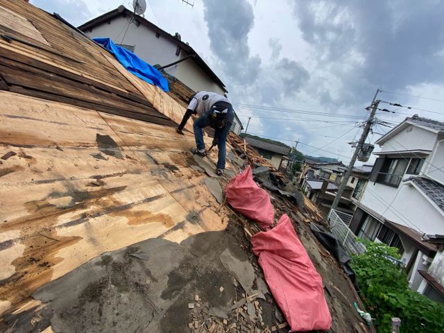 糟屋郡宇美町にて葺き替えにともなう瓦の積み下ろし作業を行う職人