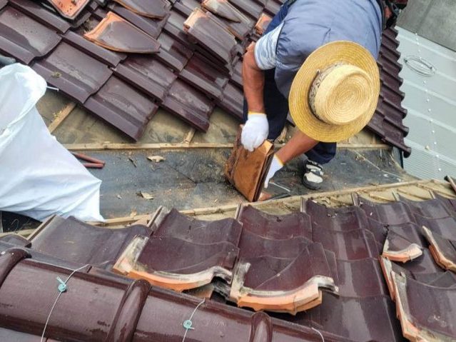 糟屋郡志免町で傷んだ谷板金を撤去している職人