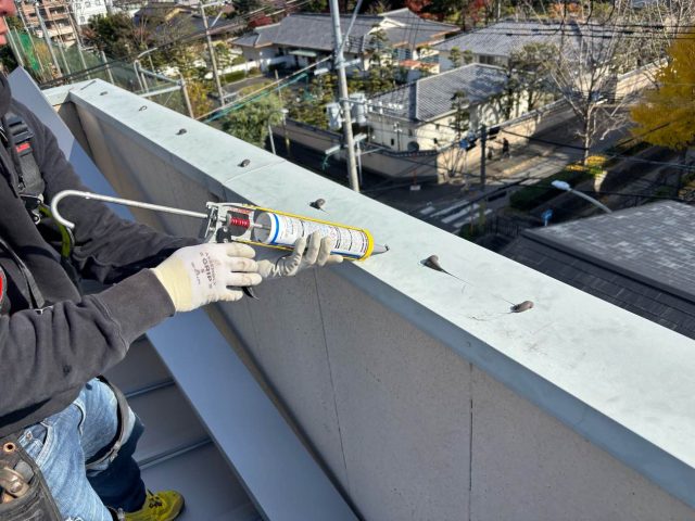 福岡市中央区でパラペットの笠木の補修をする職人