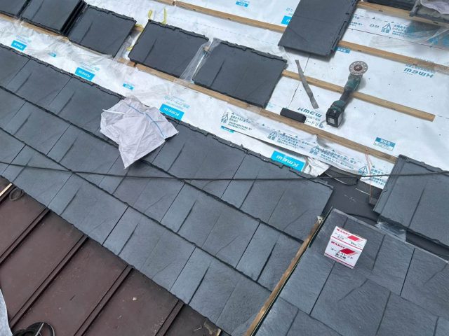 福津市の葺き替え工事で屋根材を設置中
